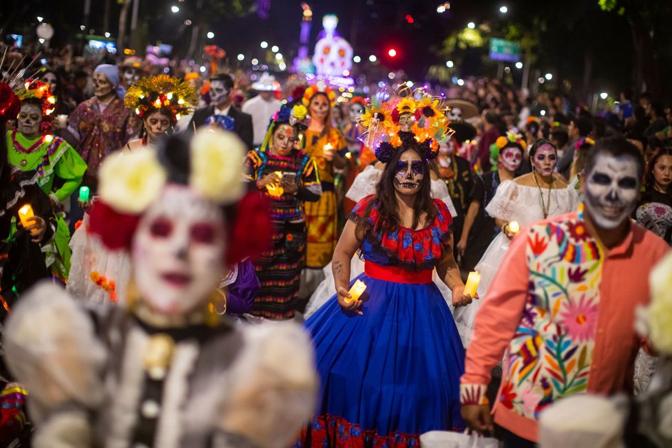 People dressed in costumes participate in the Catrinas procession as part of the celebrations for the Day of the Dead, in Mexico City, Mexico, 22 October 2023.