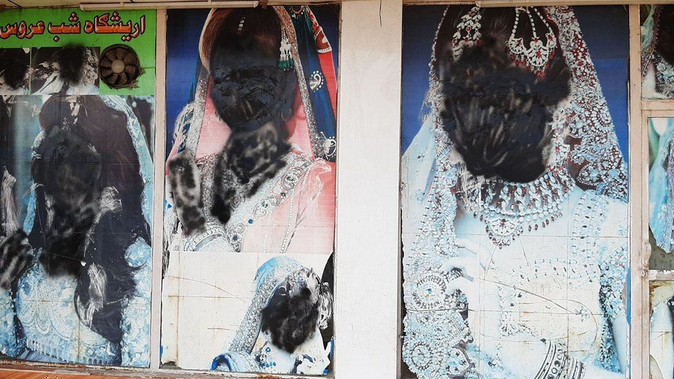 Large photos of women on the doors of beauty salons were covered up after the Taliban took control across the country