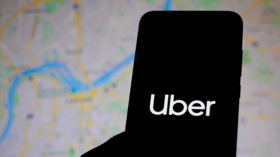 silhouette of phone with Uber logo, map background