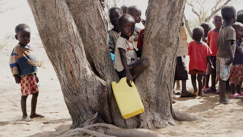 Children standing by a tree