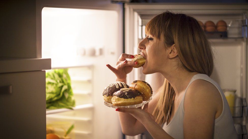 Woman eating donuts from the fridge