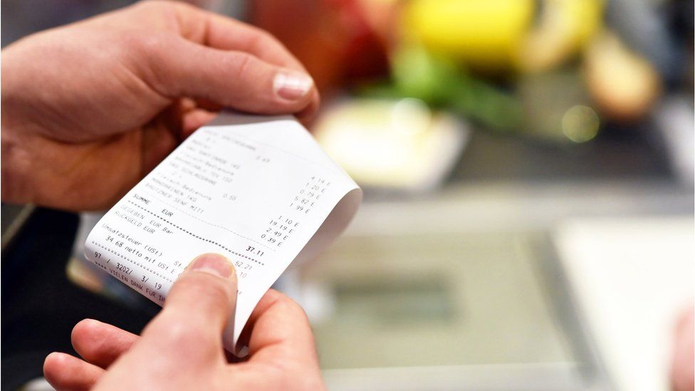 Photo of a woman looking at a receipt