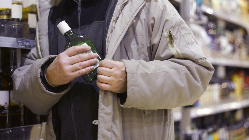 Man stealing gin from supermarket - generic