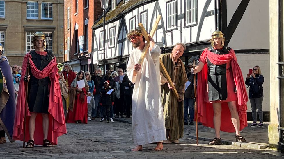 Re-enactment showing Jesus carrying a cross flanked by Roman soldiers