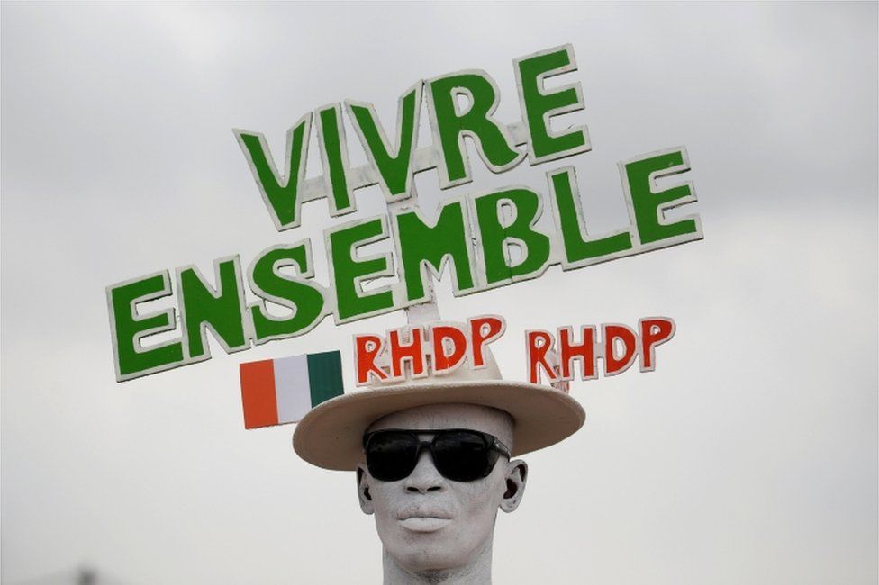 A supporter with a painted face wears a hat with a slogan in relief during a campaign rally for the October 31, 2020 presidential election in Abidjan, Ivory Coast, October 17, 2020. The slogan reads "Live together RHDP, RHDP".