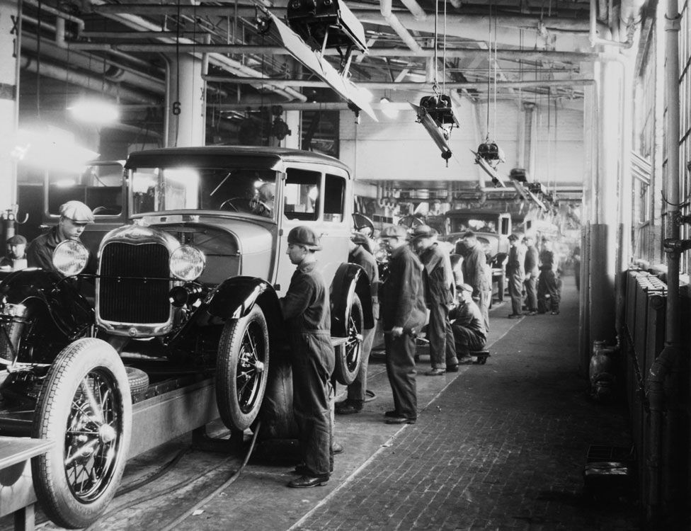 Assembly line workers inside the Ford Motor Company factory at Dearborn, Michigan pictured in 1928