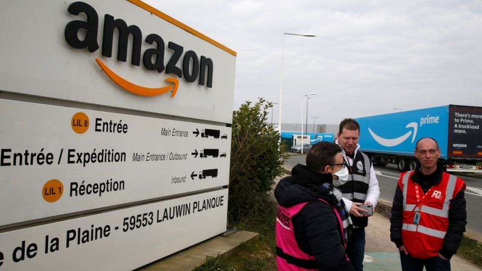 Workers stand outside an Amazon depot in France