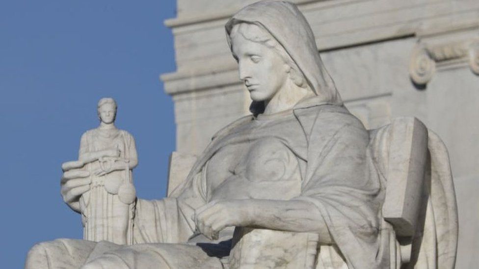 Detail of a classical marble statue on the Supreme Court building in Washington DC