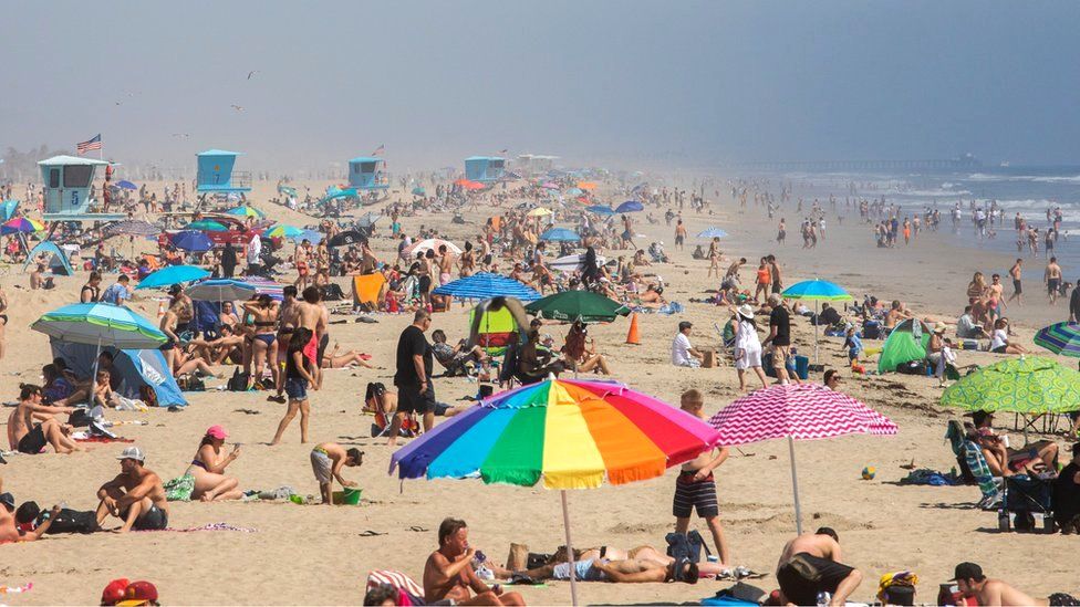People enjoy the beach amid the coronavirus pandemic on Huntington Beach, California, 25 April 2020