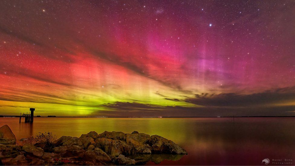 A pink, red and purple sky lit up by the Aurora Australis over Lake Elleswhere, New Zealand on 24 March