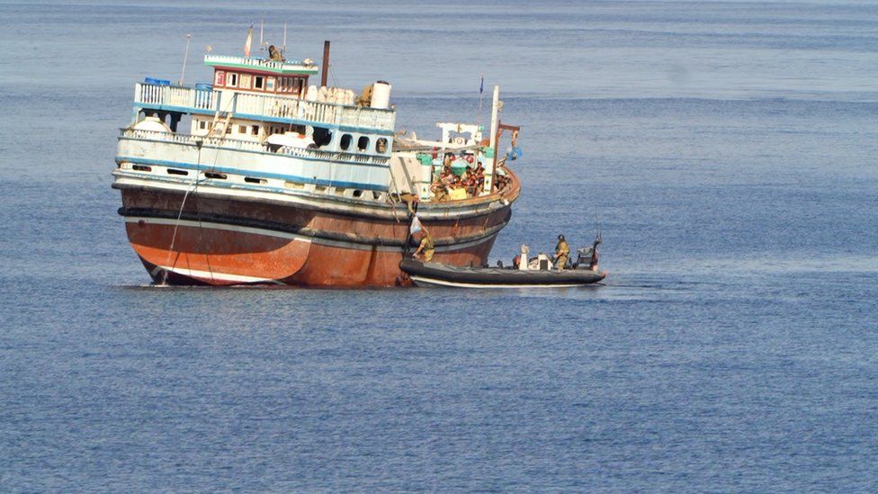 Dhow is seen with Navy boat about to board