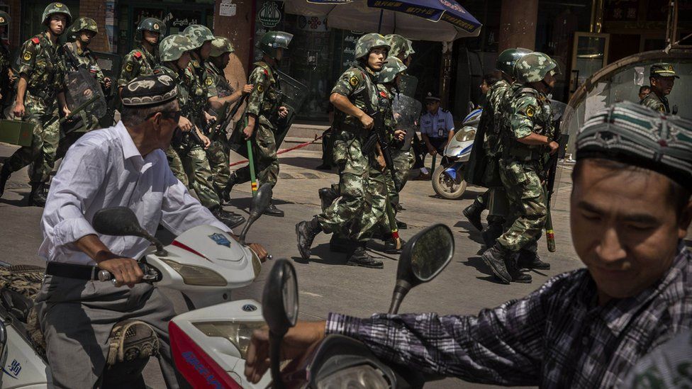 Chinese soldiers in riot gear secure the area outside a mosque in Xinjiang 30 July 2014
