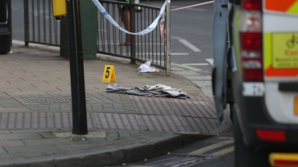 An item of clothing lies on the pavement at the junction of Palmerston Road and Wealdstone High Street