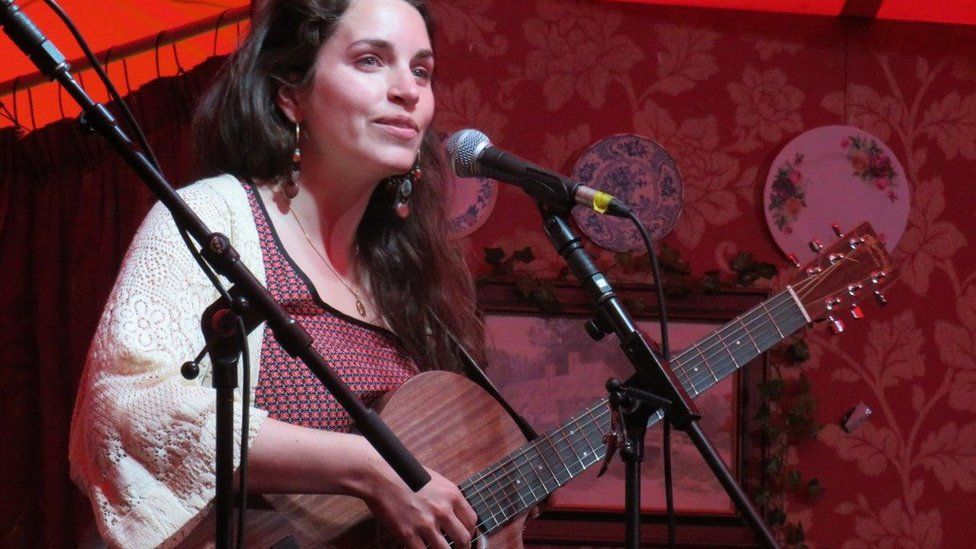 Camille Boulay performing with a guitar