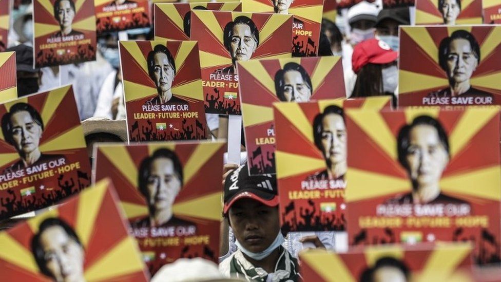 Протестующие в Мьянме держат фотографии заключенного в тюрьму лидера Аунг Сан Су Чжи