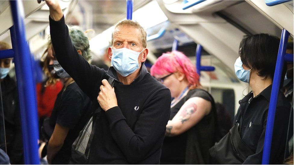 Man wearing a face mask on a London Underground train