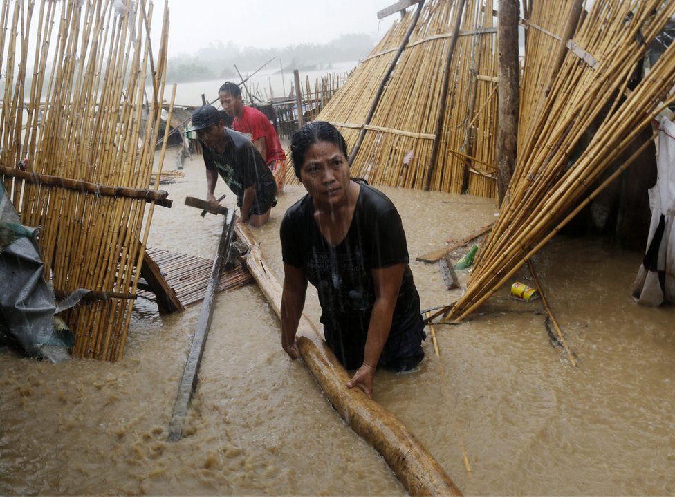 Filipino villagers collect house materials damaged by flood brought about by Typhoon Sarika in the town of San Leonardo, Nueva Ecija province, Philippines, 16 October 2016.