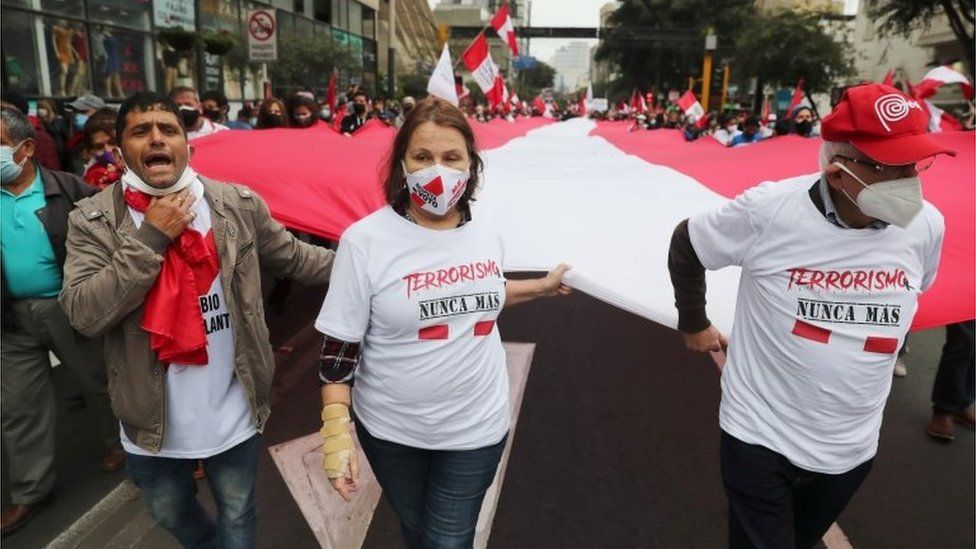 Люди в рубашках с надписью «Терроризм больше никогда» собираются, чтобы отметить 29-ю годовщину захвата Абимаэля Гусмана, основателя перуанской повстанческой группировки «Сендеро Луминосо» («Сияющий путь»), который скончался 11 сентября на военно-морской базе Кальяо, где он отбывал свою жизнь. приговор в Лиме, ​​Перу, 12 сентября 2021 г.