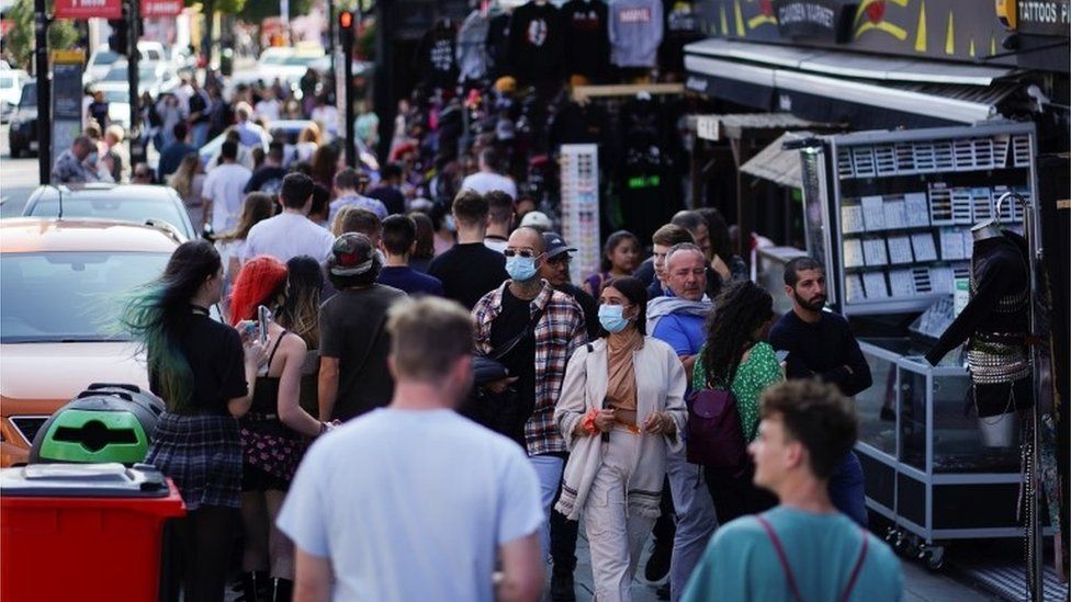 People walk along Camden High Street, amid the coronavirus disease