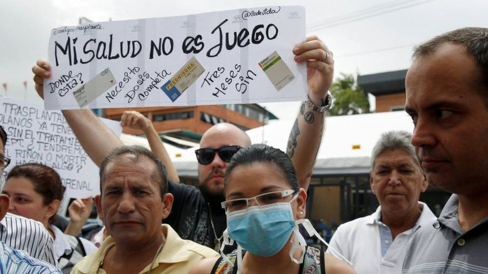 People hold a sign that reads "My health is not a game" during a protest against shortages of medicines outside a pharmacy in Caracas, Venezuela June 29, 2016