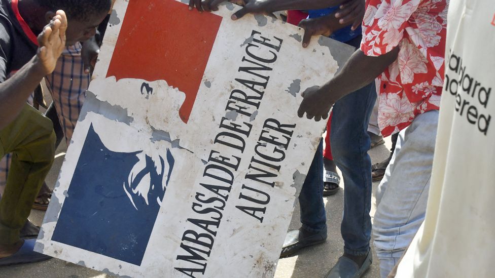 Protesters hold a sign taken from the French Embassy in Niamey during a demonstration that followed a rally in support of Niger's junta - 30 July 2023