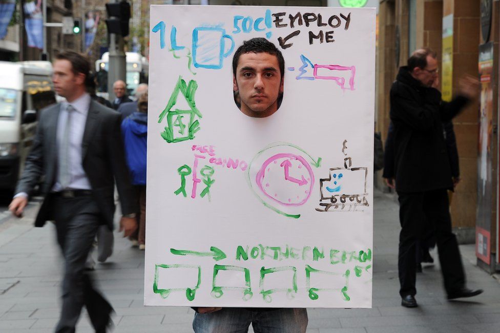 Man wearing "Employ me" sandwich board