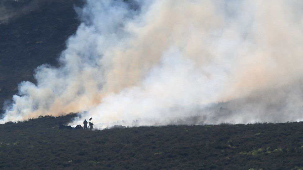 Firefighters tackle the wildfire on Saddleworth Moor
