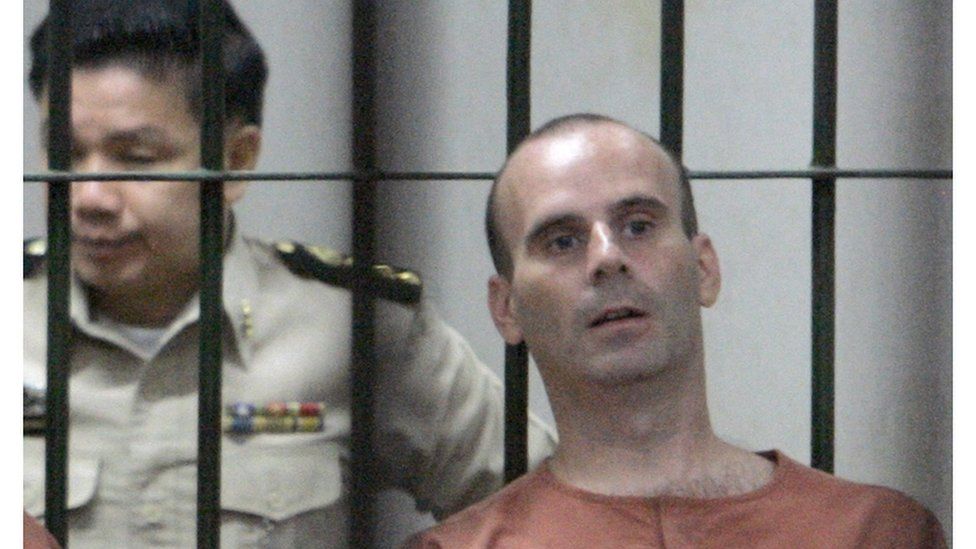 Christopher Paul Neil, right, sits next to a Thai prison official at criminal court in Bangkok, Thailand Monday, March 10, 2008. Neil was arrested in Thailand on Oct. 19, 2007 after Interpol had issued an unprecedented global appeal