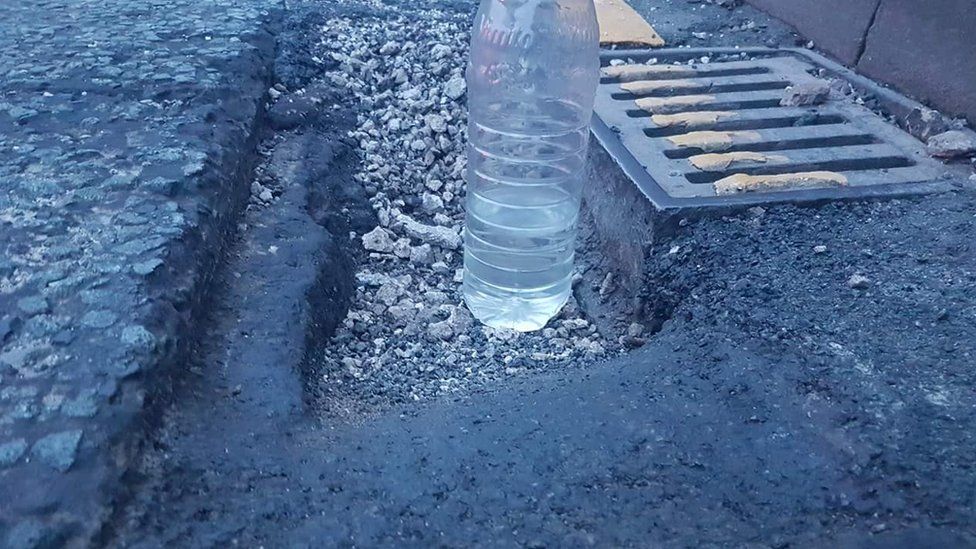 Bottle of water in a pothole