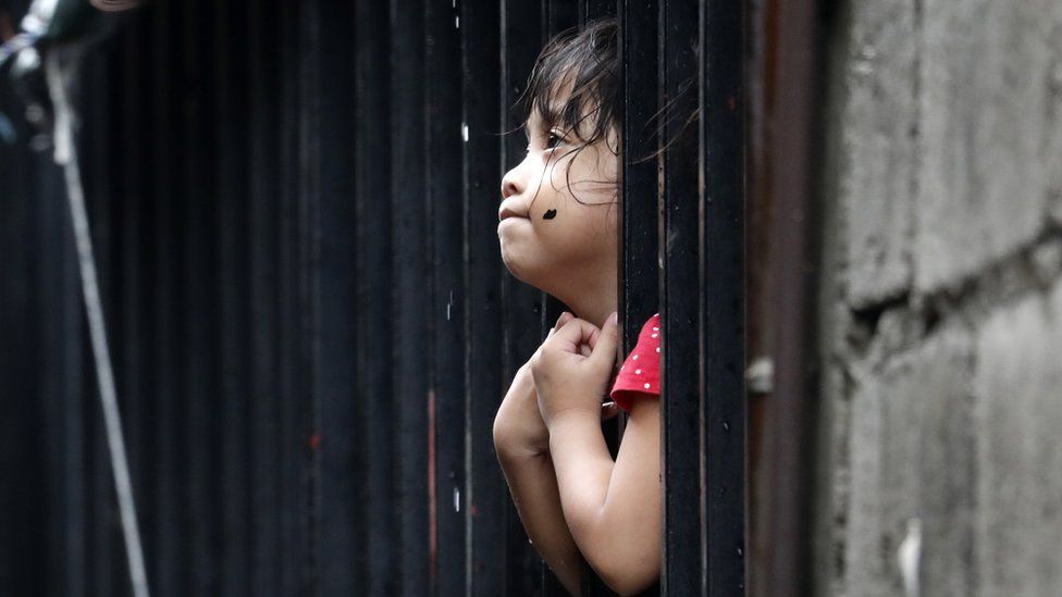 A Filipino girl is seen on a window following a flood in Marikina City