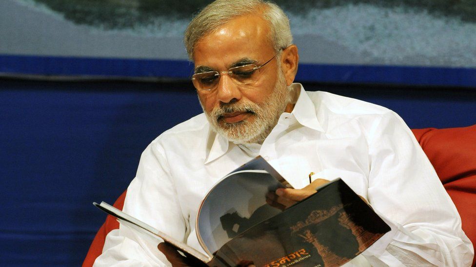 Narendra Modi leafing through a book
