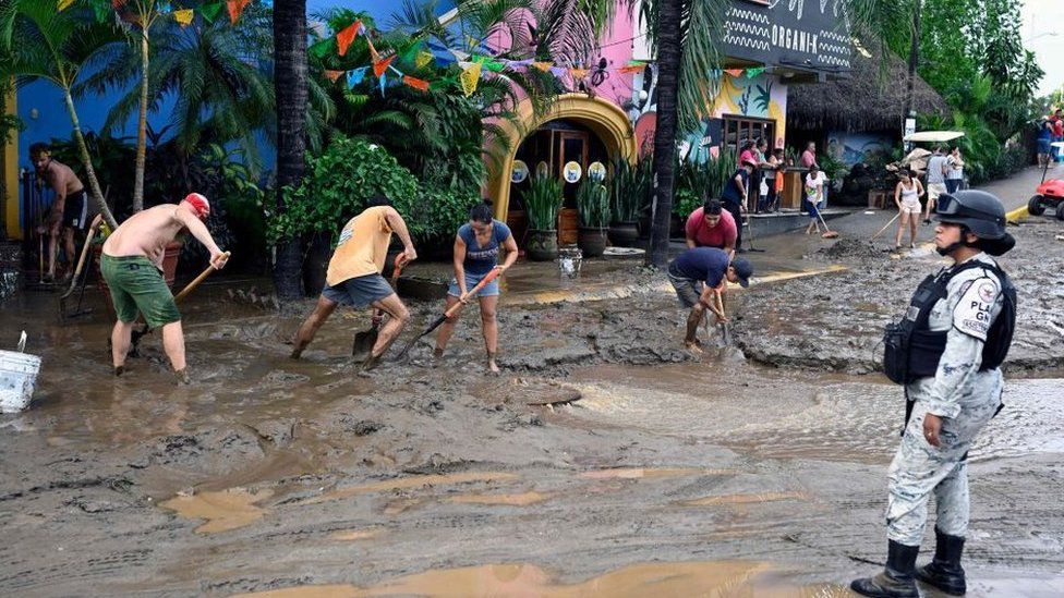 People clearing the streets of mud in Sayulita, Nayarit state