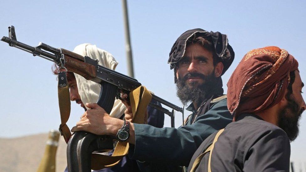 Taliban fighters stand guard in a vehicle along the roadside in Kabul on 16 August.