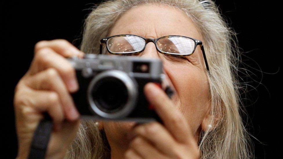 Annie Leibovitz holding camera during media preview ceremony prior to the opening of her photography exhibition in Moscow in 2011