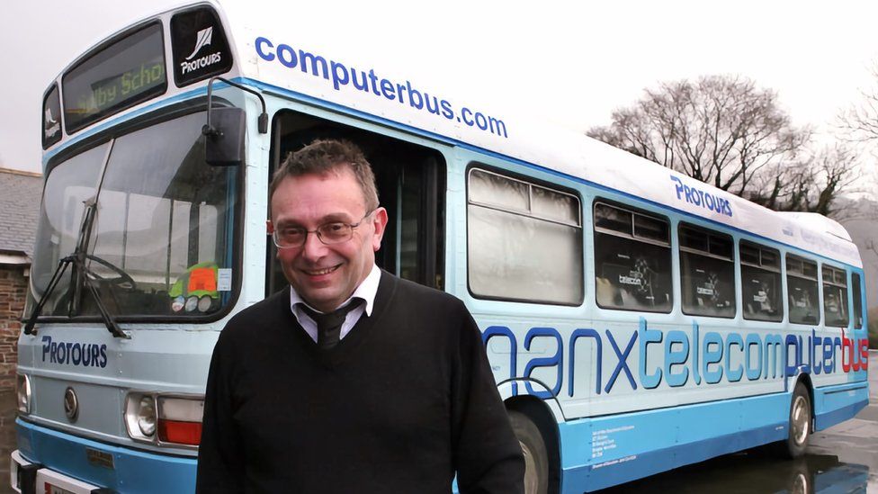 Алекс Таунсенд стоит перед компьютерным автобусом