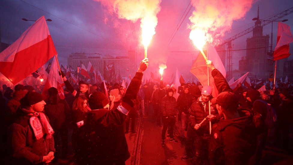 Protesters light flares and carry Polish flags during a rally, organised by far-right, nationalist groups, to mark 99th anniversary of Polish independence in Warsaw, Poland November 11, 2017.