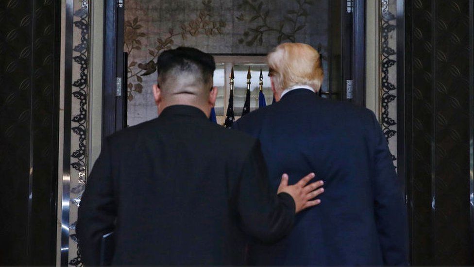 In this handout photograph provided by The Straits Times, North Korean leader Kim Jong-un (L) with U.S. President Donald Trump (R) during their historic U.S.-DPRK summit at the Capella Hotel on Sentosa island