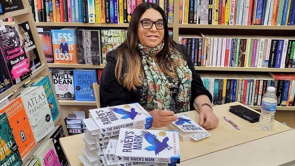 Christie Newport signs copies of her book in a bookshop