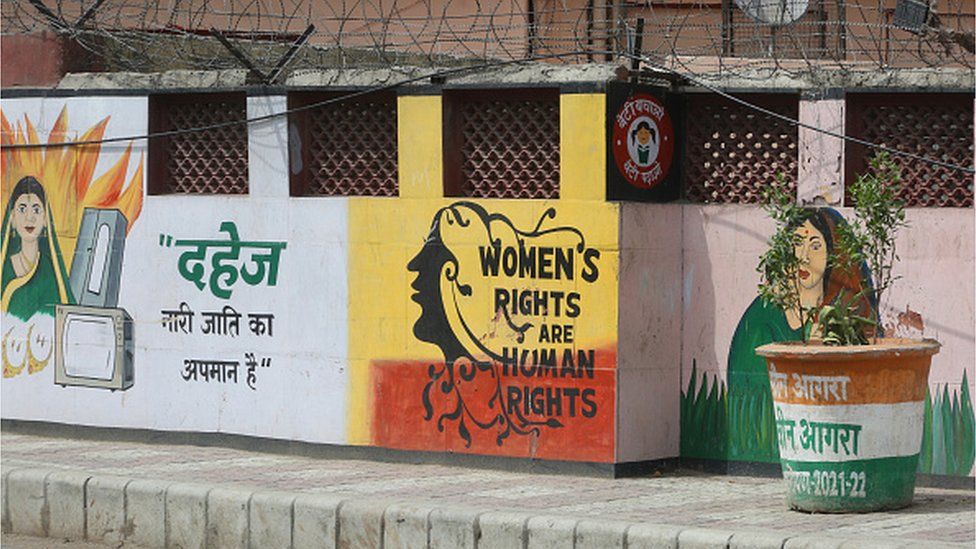 Картины на стене вдоль дороги, пропагандирующие права женщин и девочек в Агре, штат Уттар-Прадеш, Индия, 5 мая 2022 года. Здесь слова гласят: «приданое — это оскорбление женского рода»