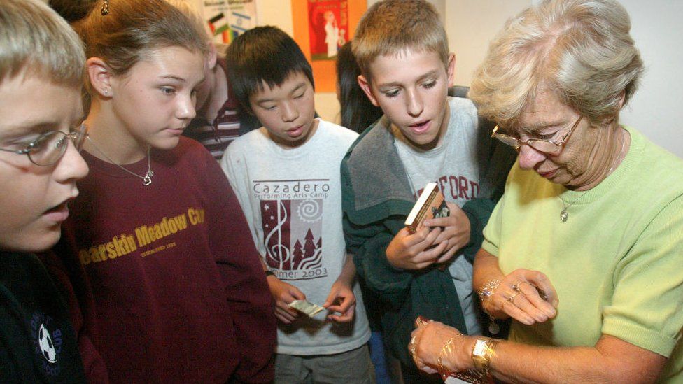 Eva Schloss shows Piedmont Middle School students her tattooed arm with the identifications number the Germans gave her