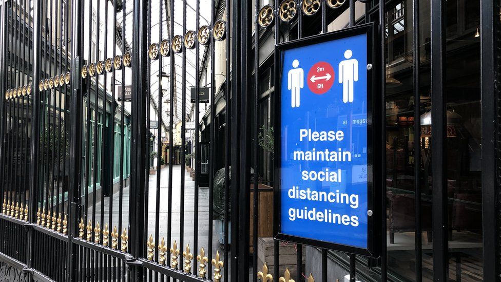 A social distancing sign on the gates to the Wyndham arcade