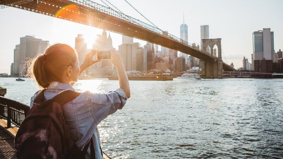 Woman takes photo of New York City skyline