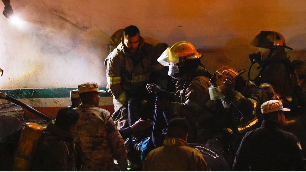 Mexican authorities and firefighters remove injured migrants, mostly Venezuelans, from inside the National Migration Institute (INM) building during a fire, in Ciudad Juarez, Mexico March 27, 2023