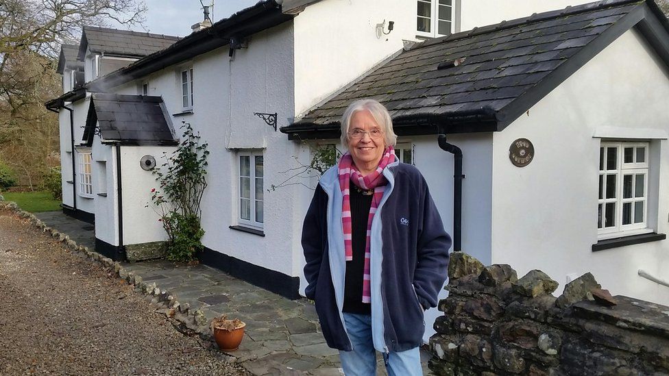 Norma Procter in front of house