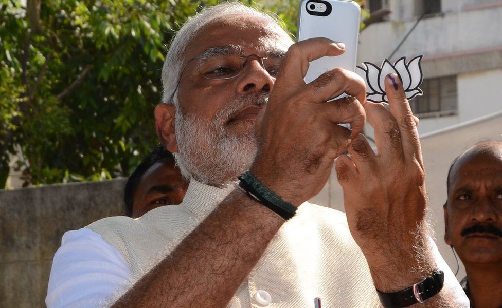 Indian Chief Minister for the western state of Gujarat and Bharatiya Janta Party (BJP) prime ministerial candidate Narendra Modi takes a 'selfie' after casting his vote at a polling station in Ahmedabad on April 30, 2014.