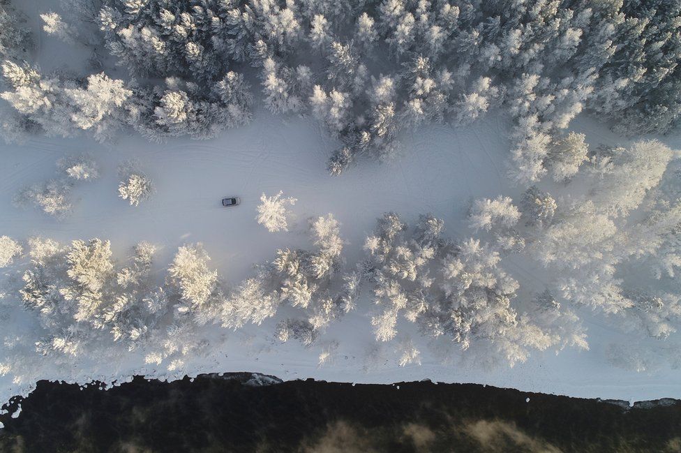 An aerial view shows a car driving along a bank of the Yenisei River, outside Krasnoyarsk, Russia, 25 January 2018.