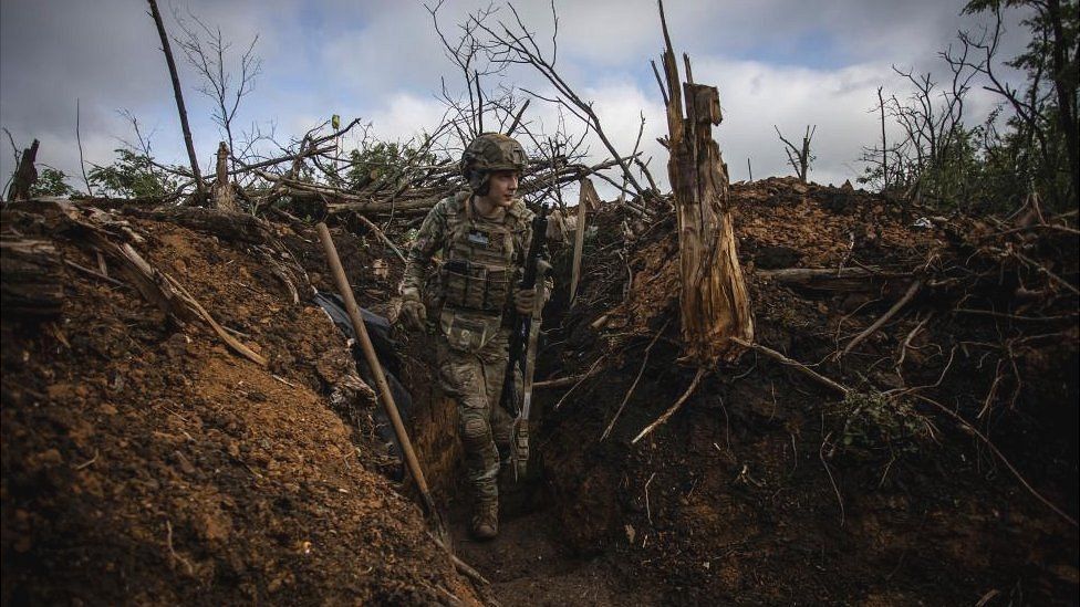 Украинский солдат стоит в окопе под Бахмутом, Украина