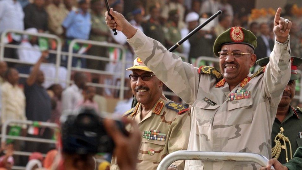 Sudan's President Omar al-Bashir (R) and Defence Minister Abdelrahim Mohamed Hussein (L) greet the crowd during a visit to the Popular Defence Forces in Khartoum on March 3, 2012.