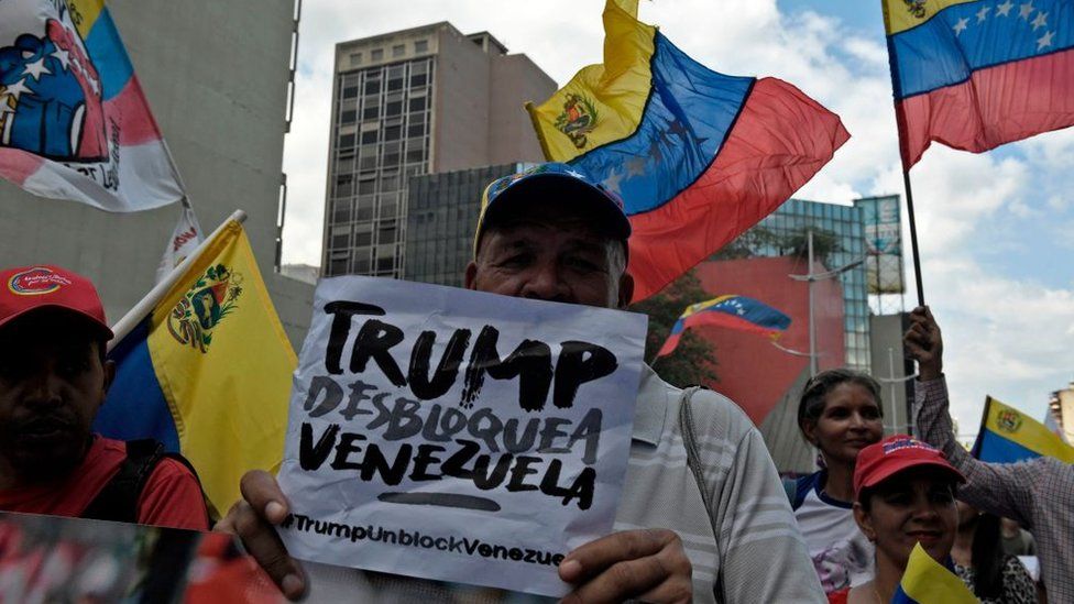 A pro-government protester rallies against US sanctions with a sign reading "Trump unblock Venezuela" in Caracas on August 7, 2019