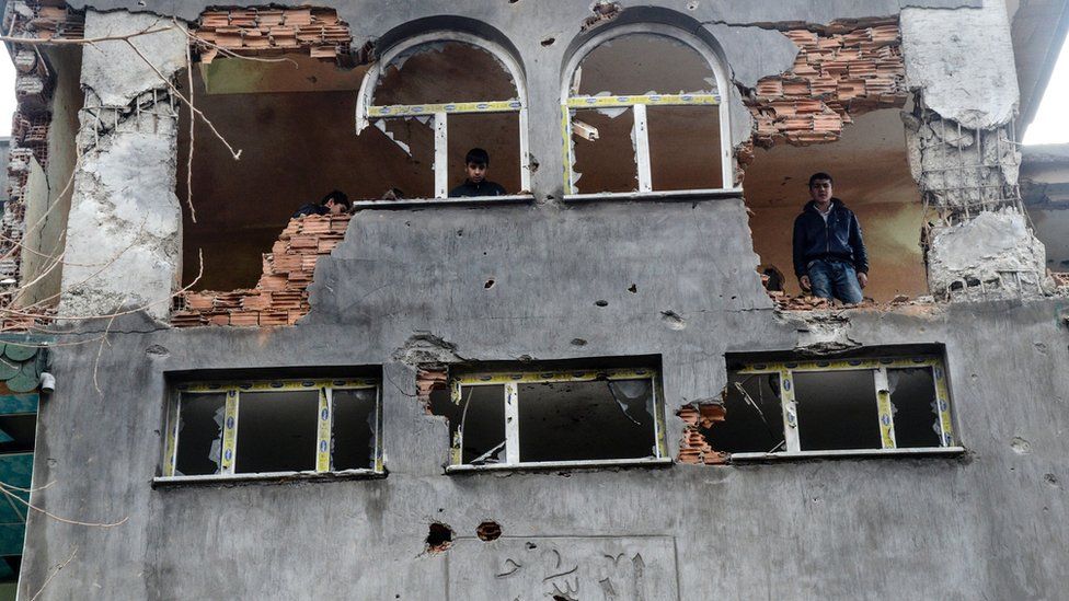 A man stands in a building damaged by fighting between Turkish government forces and Kurdish rebels in the southeastern city of Silopi in January 2016.